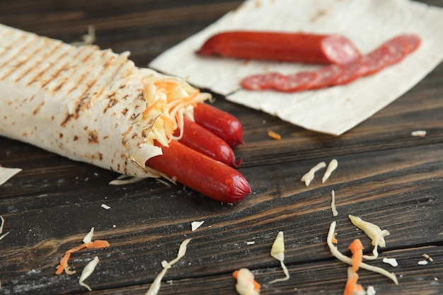 Shawarma with sausage on a wooden tablephoto with copy space