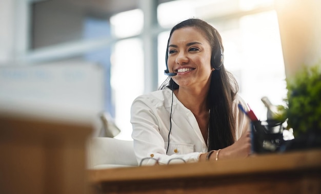 Foto le piace sempre lavorare. inquadratura di un'agente che lavora in un call center.