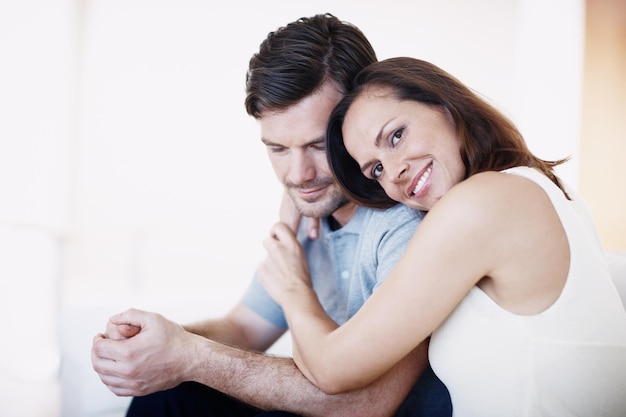 She cherishes these quiet moments with him An affectionate young couple sitting together indoors