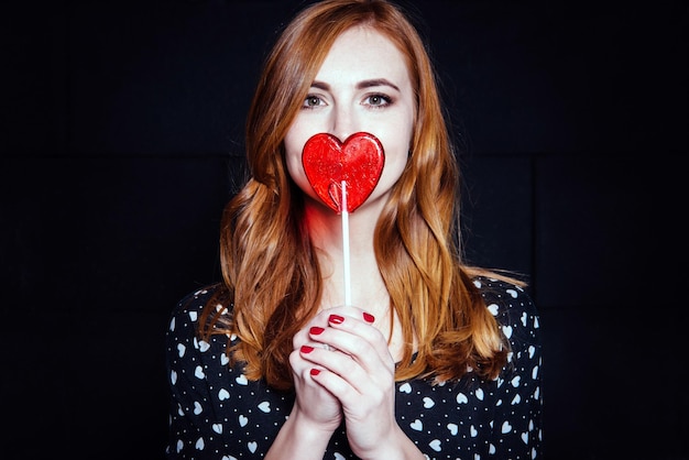 She covered her mouth with a lollipop in the form of heart