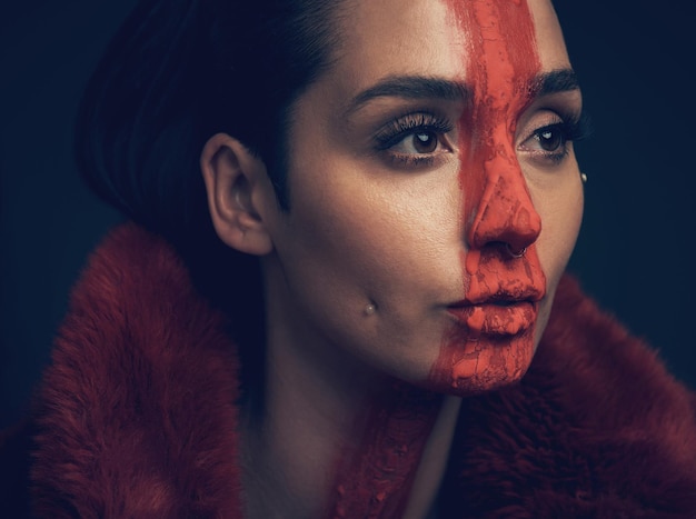 She is a flower growing everyday Studio shot of a young woman posing with paint on her face on a black background