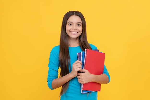 彼女は準備ができている十代の少女子供時代の幸せを勉強する準備ができています幸せな子供はメモ帳で宿題をするつもりです