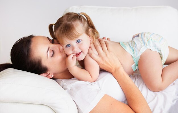 La ama così tanto una bambina carina baciata da sua madre