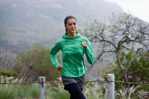 She progresses in her fitness everyday A young woman sprinting along a mountain road on a crisp morning