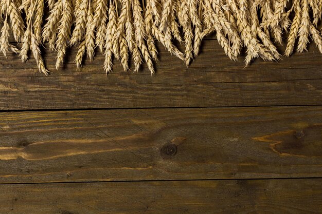 Sheaf of wheat ears on wooden table