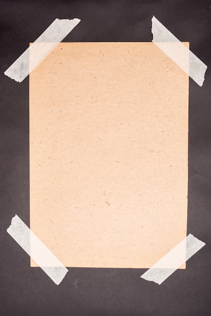 A sheet of craft paper glued with white masking tape on a black background