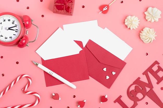 sheet of paper for message, meringue,red envelope, gift box, pen, clock, candle. Valentines day