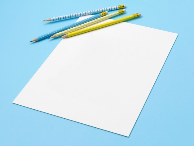 Photo sheet of paper with blue and yellow striped pencils.