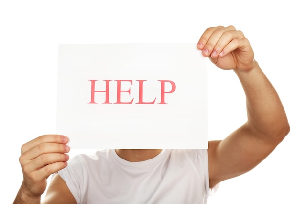 Sheet of paper with Help sign in male hands isolated on white