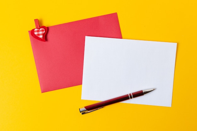 Sheet of paper with red hearts for message on yellow