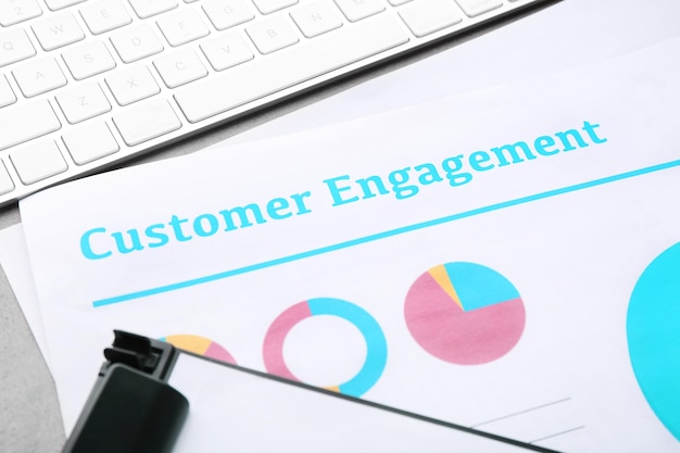 Sheet of paper with text CUSTOMER ENGAGEMENT on office table