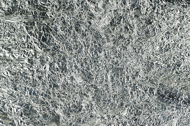 Sheet of silver leaf background with shiny crumpled uneven surface