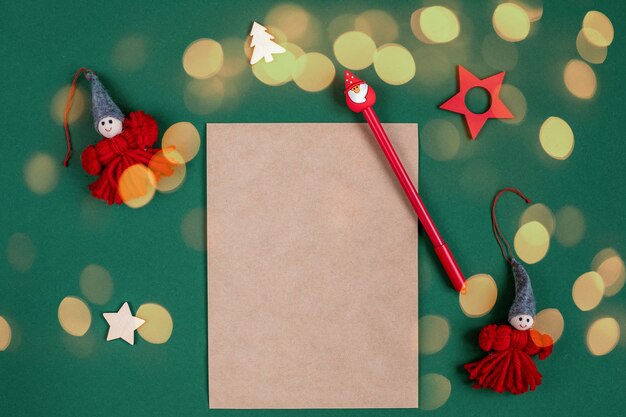 Photo sheet for writing to santa and christmas accessories around on green background with lights bokeh