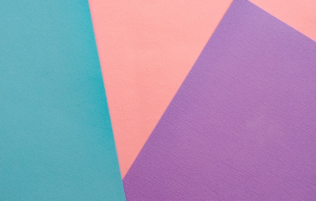 Sheets of colored paper background. Pink, Turquoise, purple.