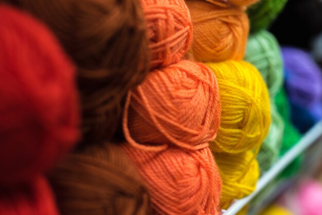 Полочка с большим количеством цветной пряжи для самостоятельного вязания. выбор красочной шерсти пряжи на витрине