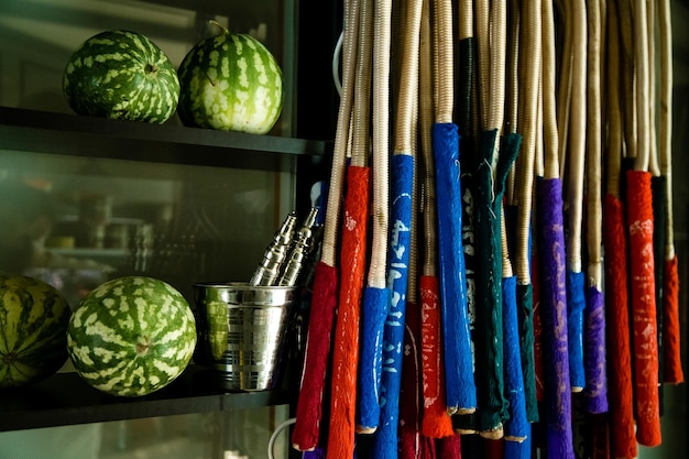 A shelf with different colored shirts and a watermelon on it.