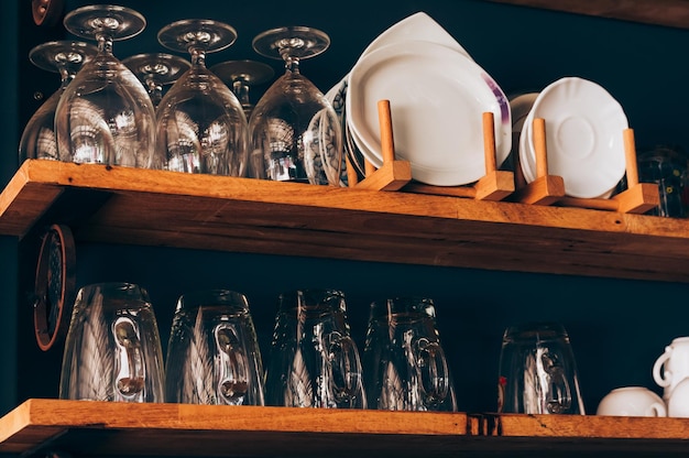 Photo a shelf with wine glasses and plates on it