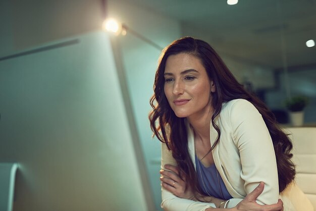 Shell doet er alles aan om de klus te klaren Bijgesneden opname van een jonge zakenvrouw die laat aan het werk is op een computer in een kantoor