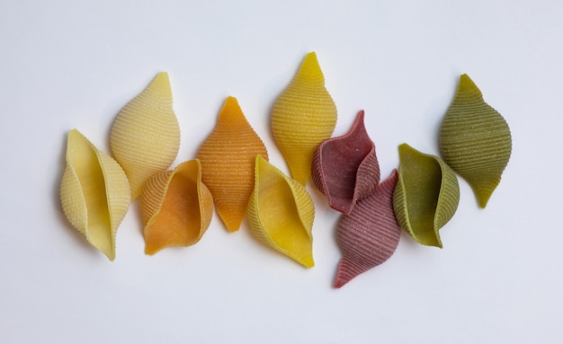Shell noodles in 5 colors and flavors. Raw whole grain pasta