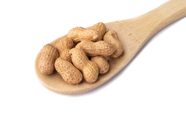 Shelled peanuts in a spoon isolated over white background