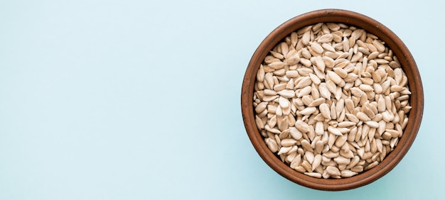 Shelled sunflower seeds over blue background