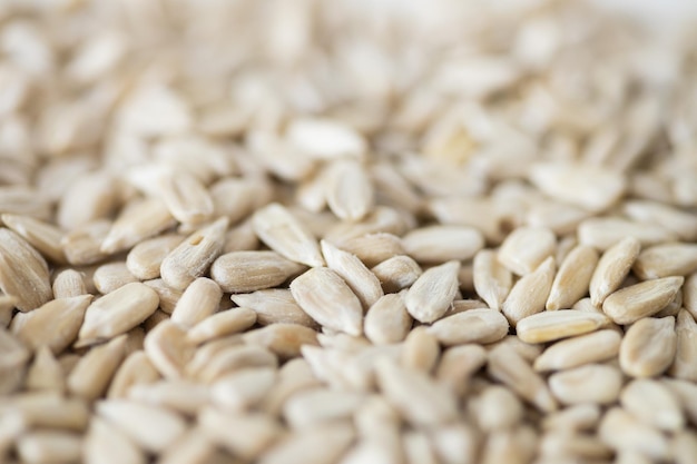 Shelled sunflower seeds over white background