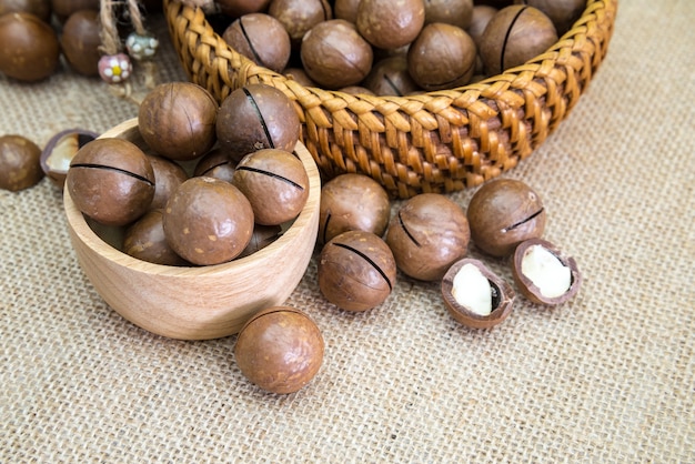 Shelled and unshelled macadamia nuts on wood vintage table