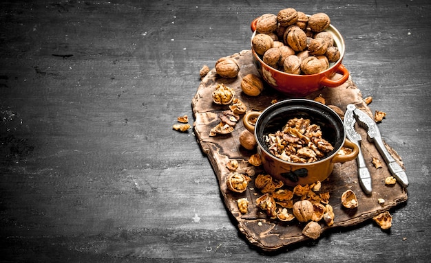 Shelled walnuts in bowl with Nutcracker on black chalkboard