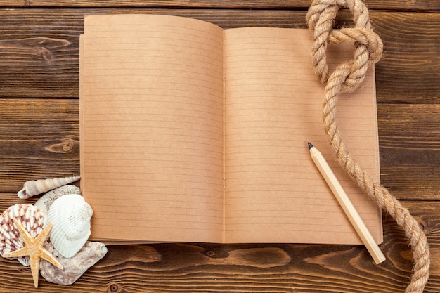 Shells and notepad on wooden table. 