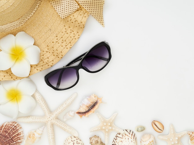 Shells, starfish, straw hats, sunglasses on a white background