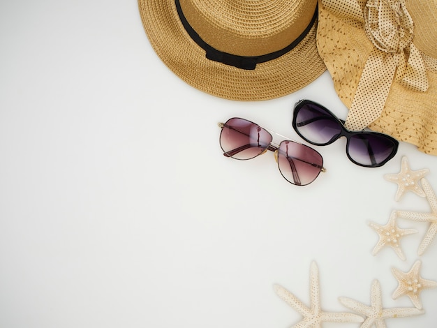 Shells, starfish, straw hats, sunglasses on a white background