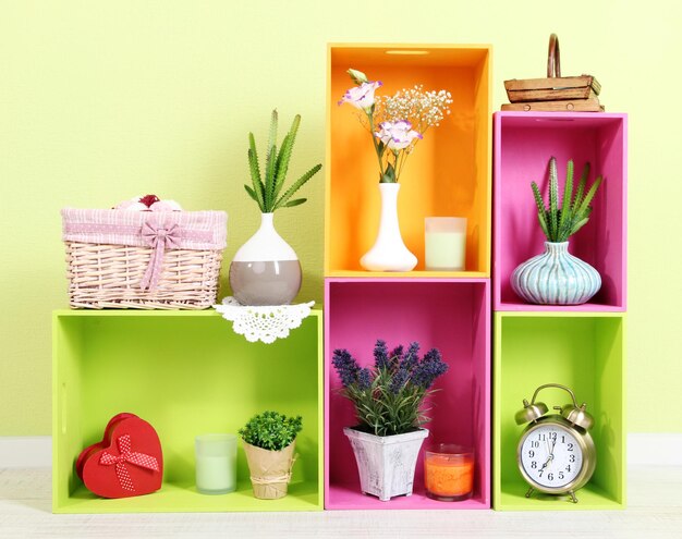 Photo shelves of different bright colors with decorative addition on wall background