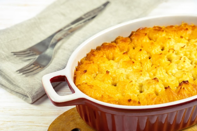 Shepherd's Pie or Cottage Pie traditional British dish on white wooden backgfound