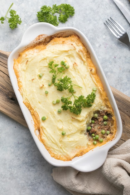 Shepherd's Pie met gehakt, aardappel en kaas op houten achtergrond, bovenaanzicht, kopie ruimte. Traditionele zelfgemaakte Ierse braadpan