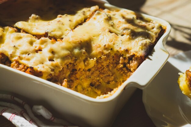 Photo shepherd's pie in white baking dish on the table