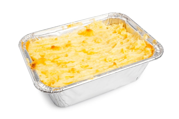 Shepherds Pie Traditioneel Engels eten geserveerd in aluminiumfolie container geïsoleerd op een witte achtergrond