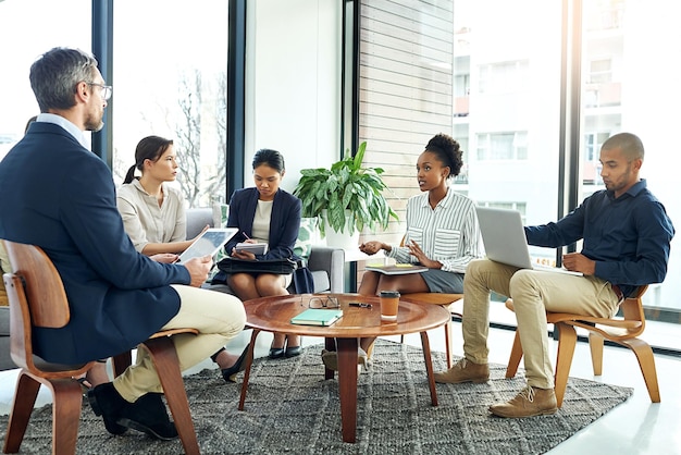 Shes bringing some new ideas to the table Shot of a group of work colleagues talking together in a meeting in an office