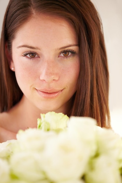 Shes the fairest of them all Portrait of a beautiful young woman smiling and holding a bouquet of flowers