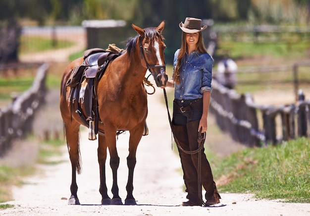 彼女はいつかチャンピオンになるだろう牧場の周りで彼女の馬を導く牛の女の子のショット