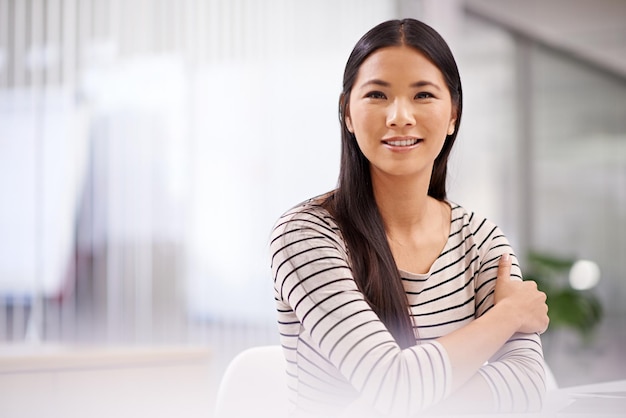 Shes real gogetter Портрет привлекательной азиатской деловой женщины, сидящей в своем офисе