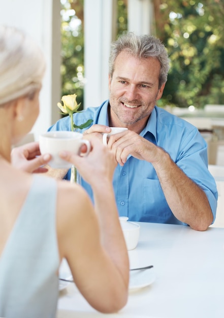 Photo shes still so beautiful even after all these years happy mature couple enjoying a cup of coffee outdoors