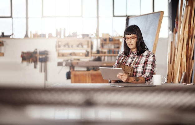 Shes in this game to create Cropped shot of an attractive young woman working on her tablet while sitting in her creative workshop