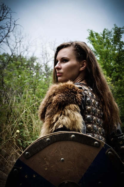 Foto shieldmaiden cosplay ragazza vichinga una donna con una spada e un'ascia abbigliamento medievale