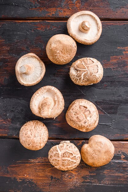 Shiitake mushrooms set on old wooden table, top view.