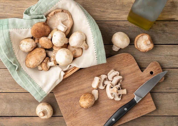 Shimeji portobello e funghi di parigi in un cesto con fette su tavola di legno