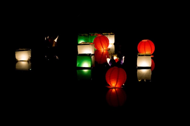 Shining lanterns of different color in the dark water