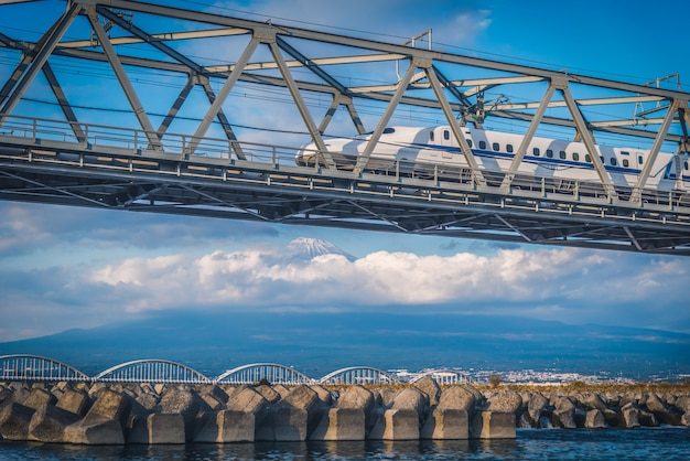 Shinkansen train on railway with Mt. Fuji at Shizuoka, Japan.