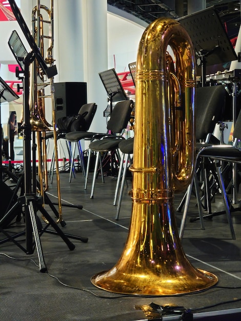 Foto trombone in ottone lucido in piedi su un palco con uno sfondo dell'attrezzatura della band in una vista a livello del pavimento ad angolo basso