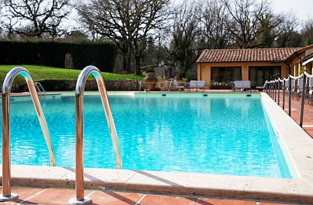 Shiny chrome ladder in the pool with blue water