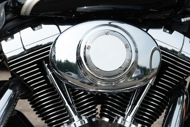 Shiny chrome motorcycle parts closeup a large tourist motorbike\
engine cylinders and cooling fins closeup